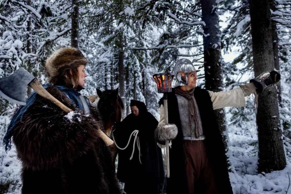 Kvinna och man diskuterar vägval i vinterskog.