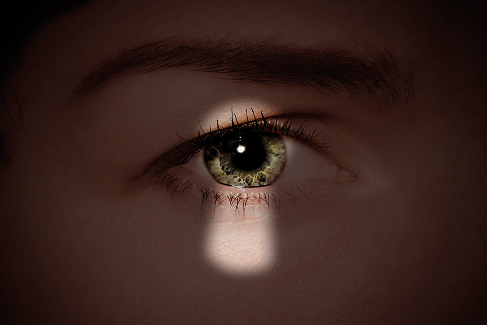 Foto på ett öga med en skugga av ett nyckelhål