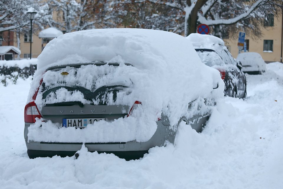 översnöade bilar parkerade längs gatan